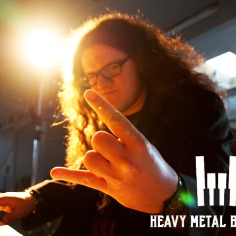 Heavy Metal Barpiano Pianist zeigt am Piano sitzend die Heavy Metal Pommesgabel - dein perfekter Musik Act für deine Metal Hochzeit.