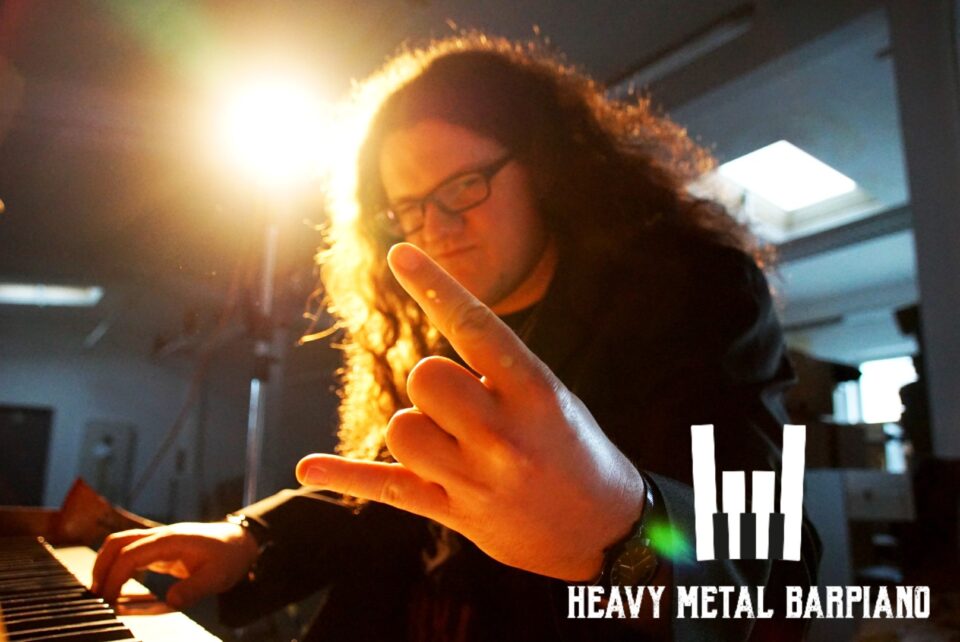 Heavy Metal Barpiano Pianist zeigt am Piano sitzend die Heavy Metal Pommesgabel - dein perfekter Musik Act für deine Metal Hochzeit.