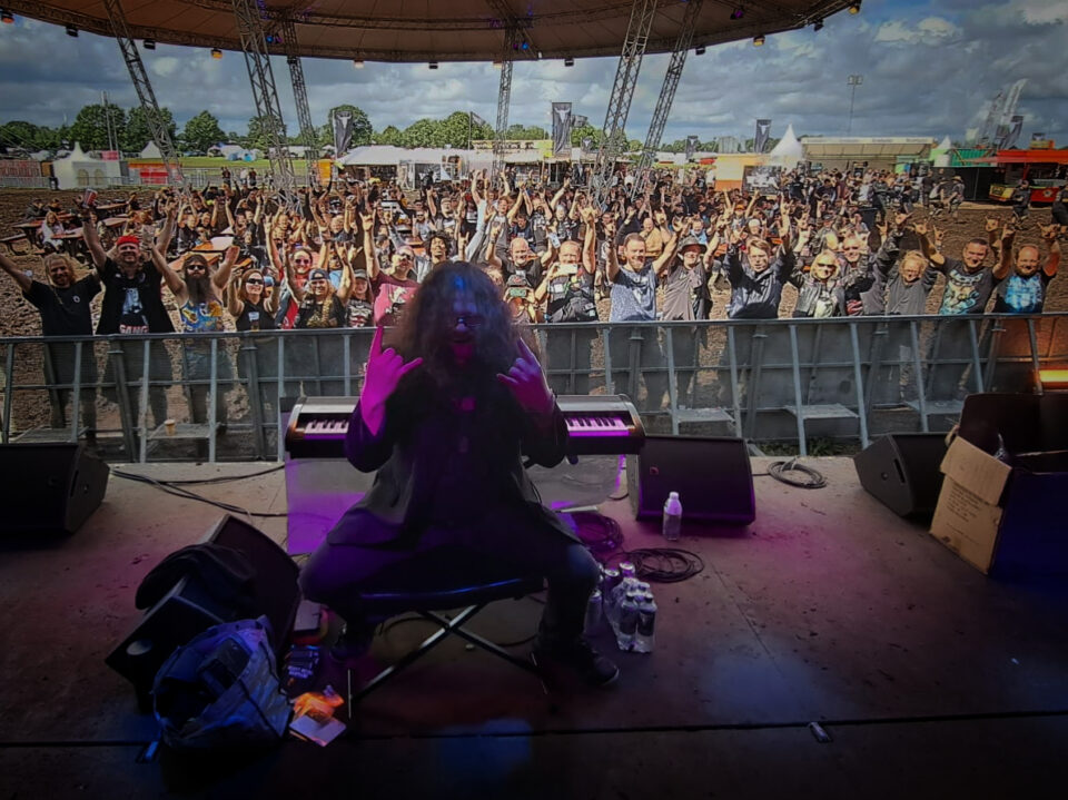 Heavy Metal Barpiano Musiker auf der Bühne in Wacken vor einer feiernden Menschenmenge - die beste Wahl für Live-Musik auf deiner Metal Hochzeit.