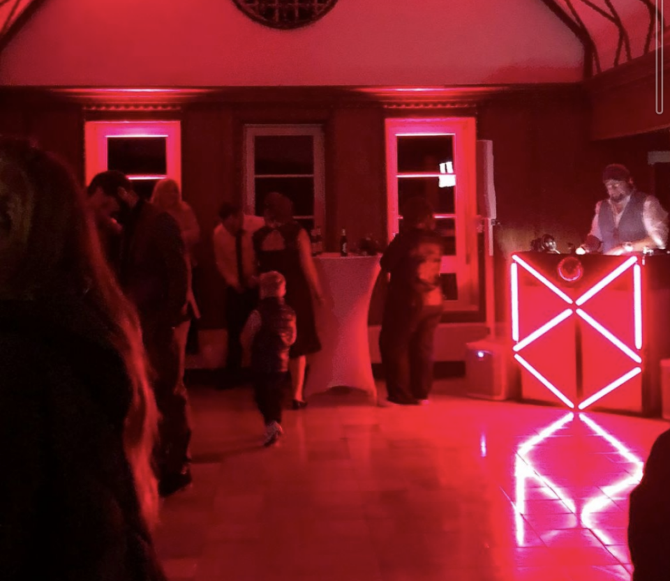 Tanzfläche in rotem Licht, DJ Tom Nawa legt auf – Hochzeitsmusik für Nerd Hochzeit Ideen mit echtem Festivalfeeling