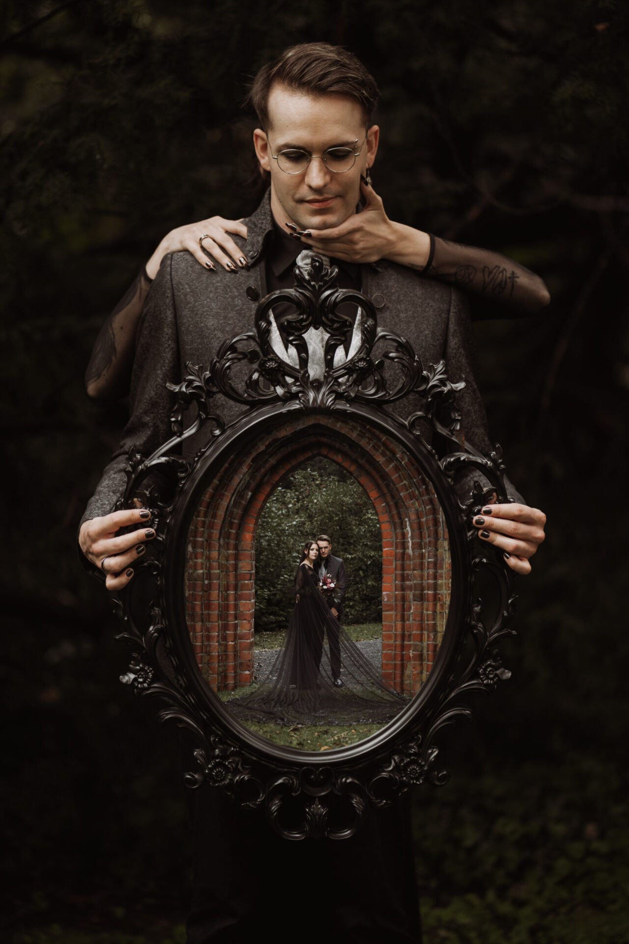 Hochzeitsfotografie von Patricia Bakker bei Hell Yes! Weddings: Gothic-Paarshooting mit Spiegelrahmen – Brautpaar im schwarzen Look in der Spiegelreflexion, das perfekte Foto einer alternativen Hochzeit.